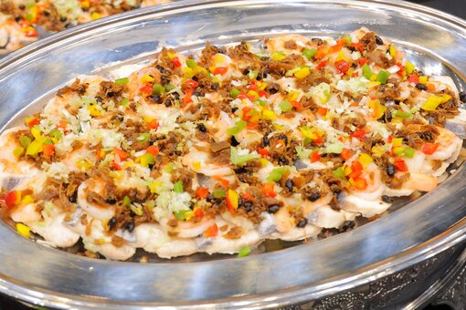 Platter of shrimp with colorful vegetable toppings.