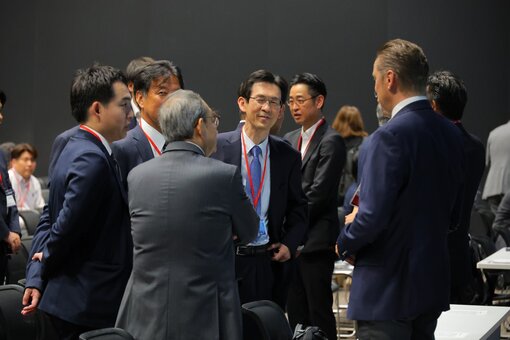 Group of people standing and talking at an event.