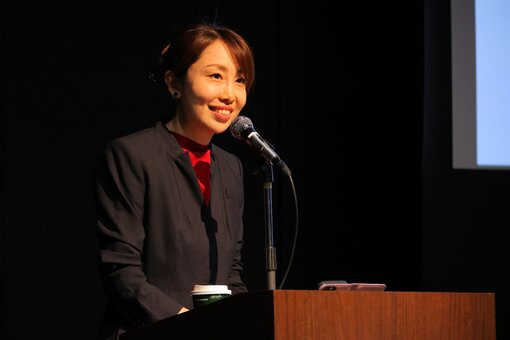 Person speaking with a microphone during a presentation.