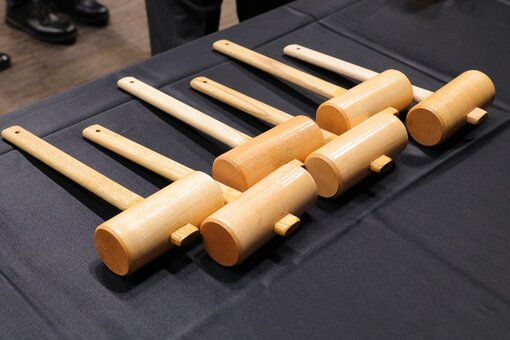 Six wooden mallets on a black table.